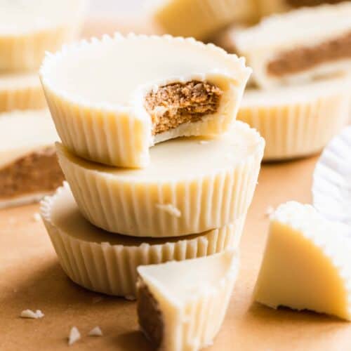 Stack of white chocolate Reece's cups with a bite taken out of one.