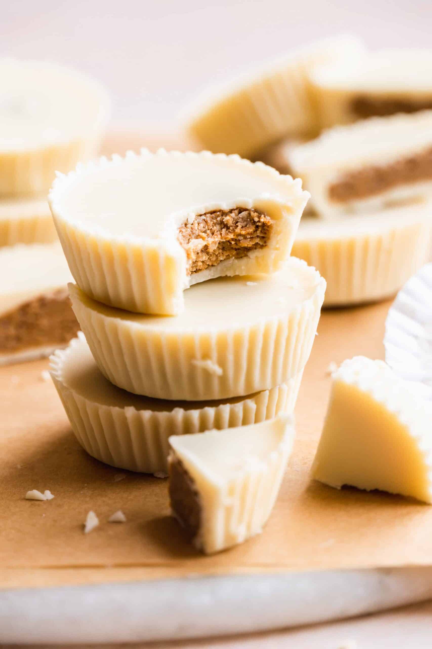 Stack of white chocolate reese's cups with a bite taken out of the top one.