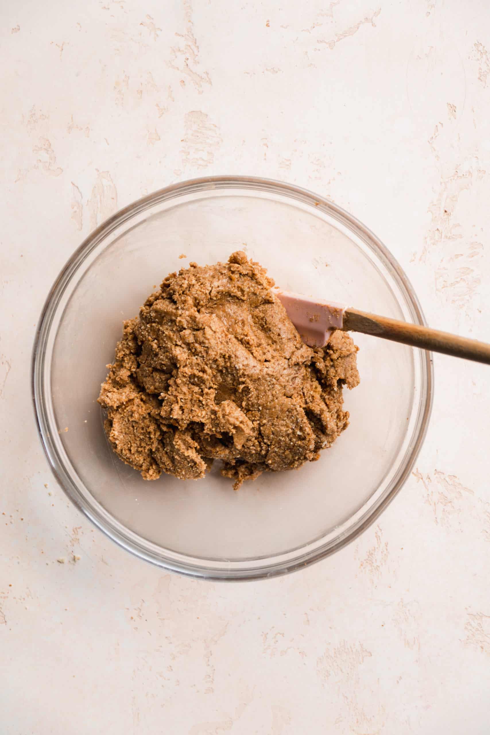 Peanut butter mixture in a glass bowl with a spatula.