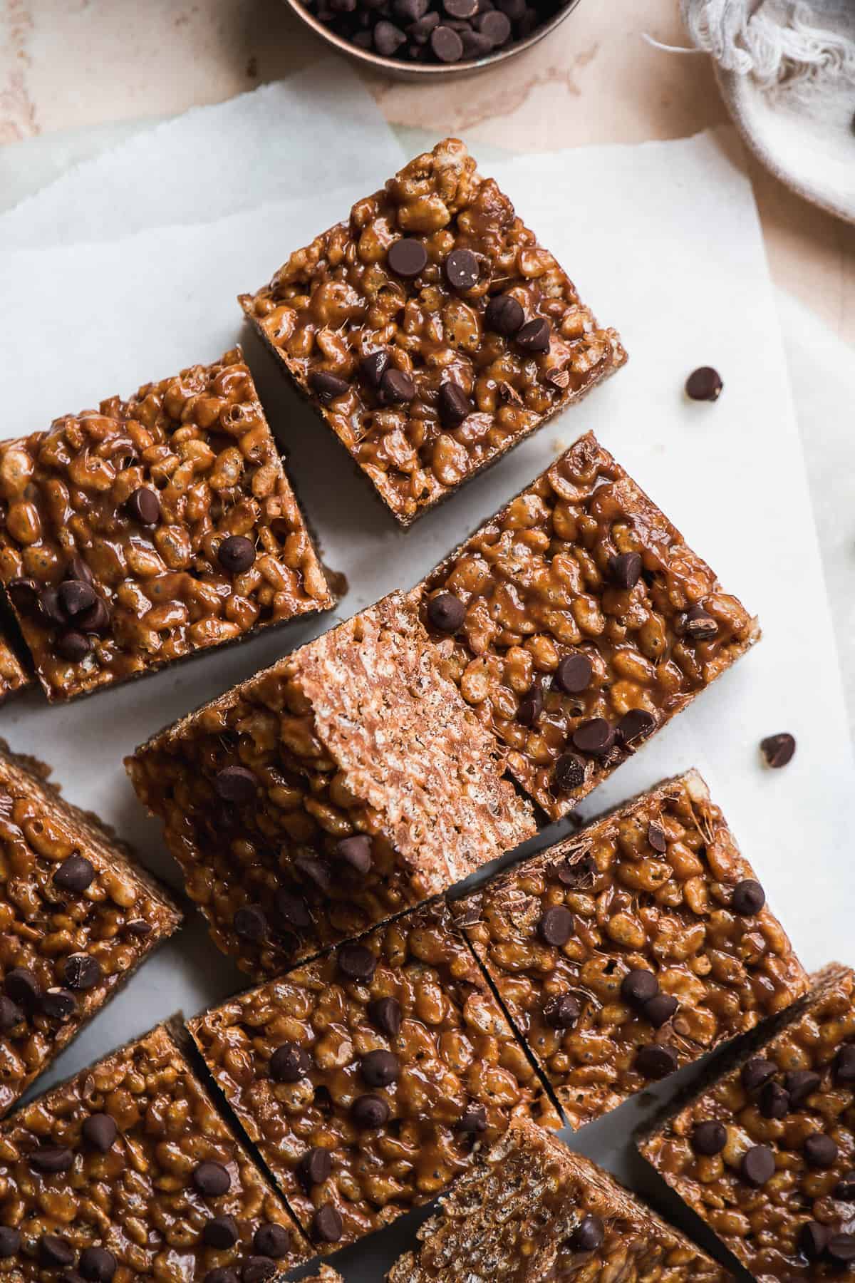 Chocolate rice krispie treat squares on white paper.