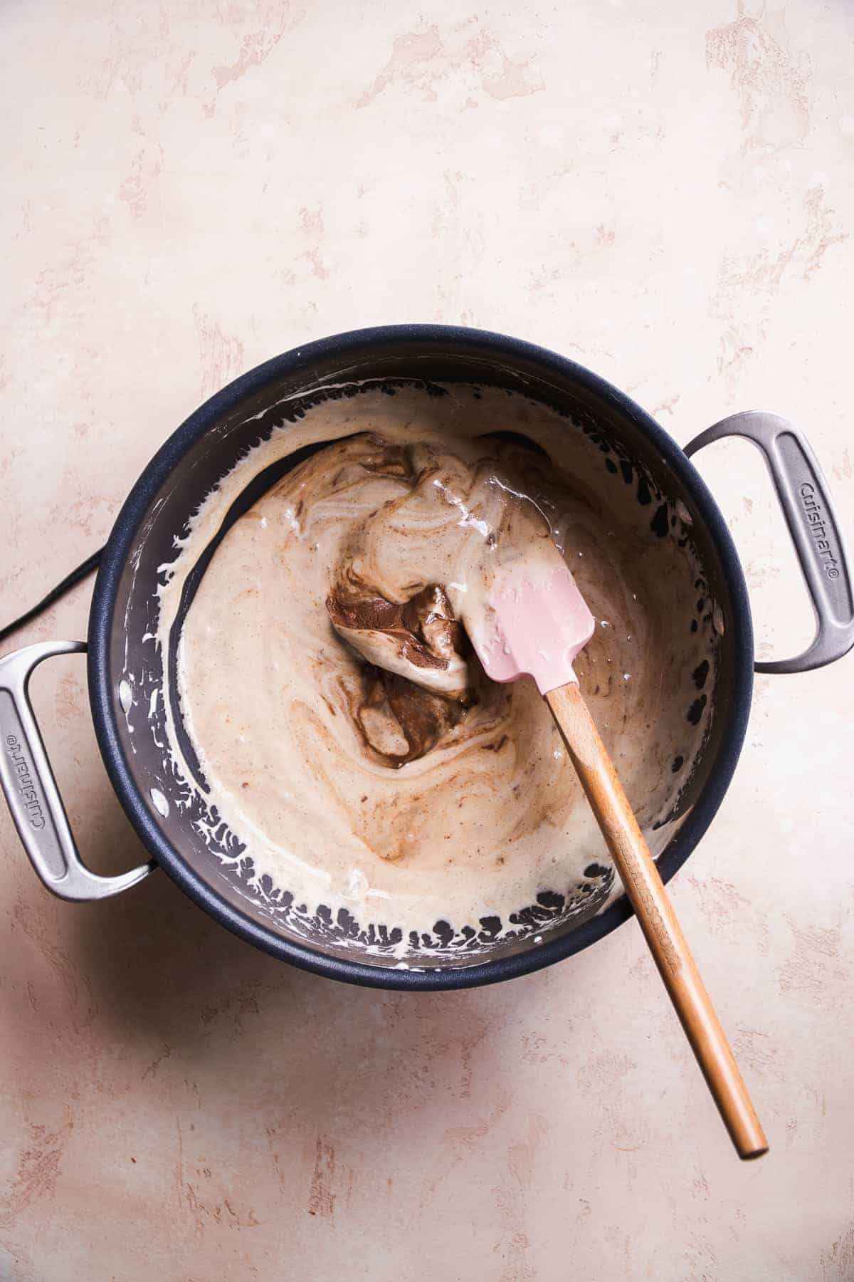 Overhead view of a pot with melted marshmallows and chocolate being mixed in.