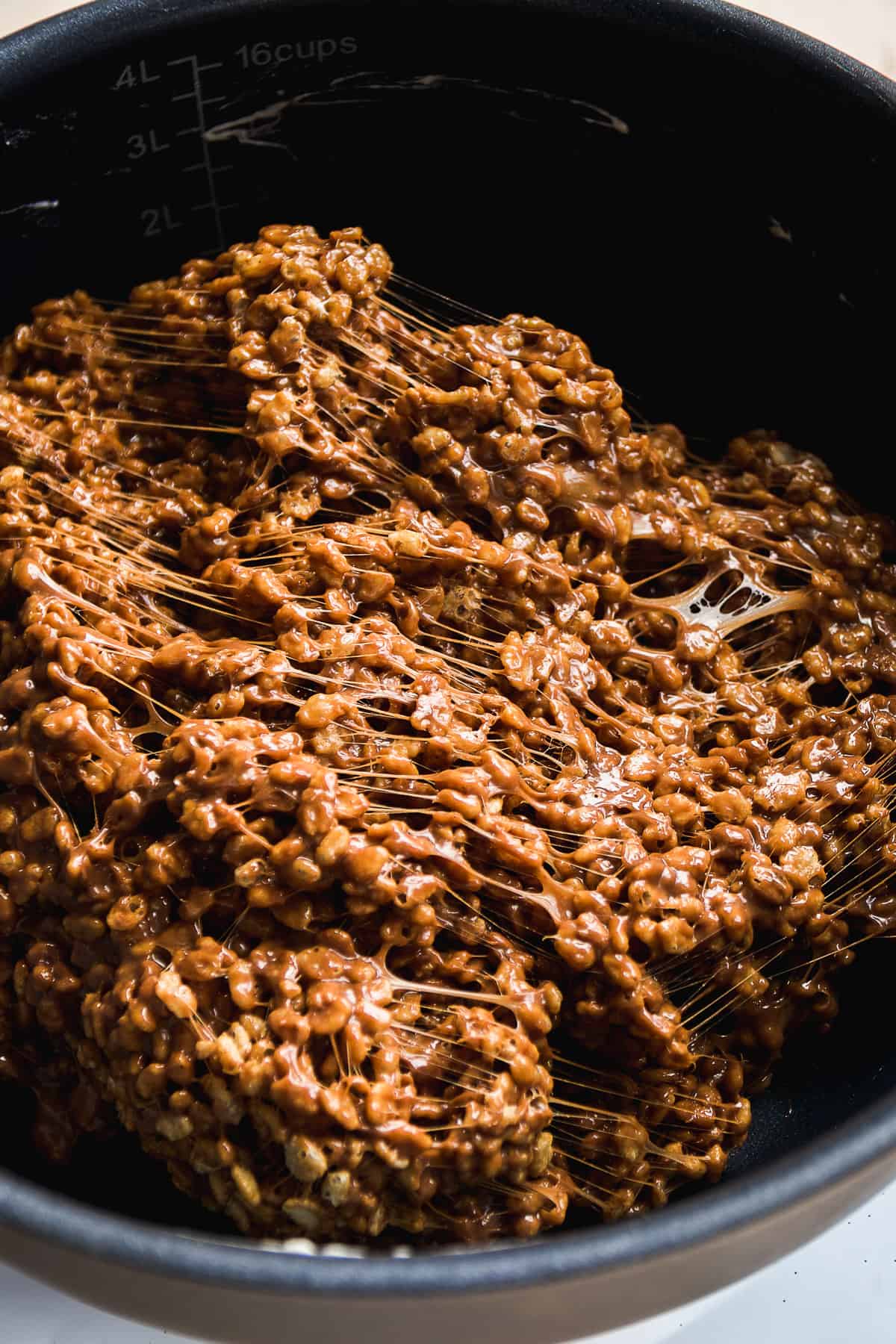 Chocolate sunflower butter rice krispies being mixed in a black pot.