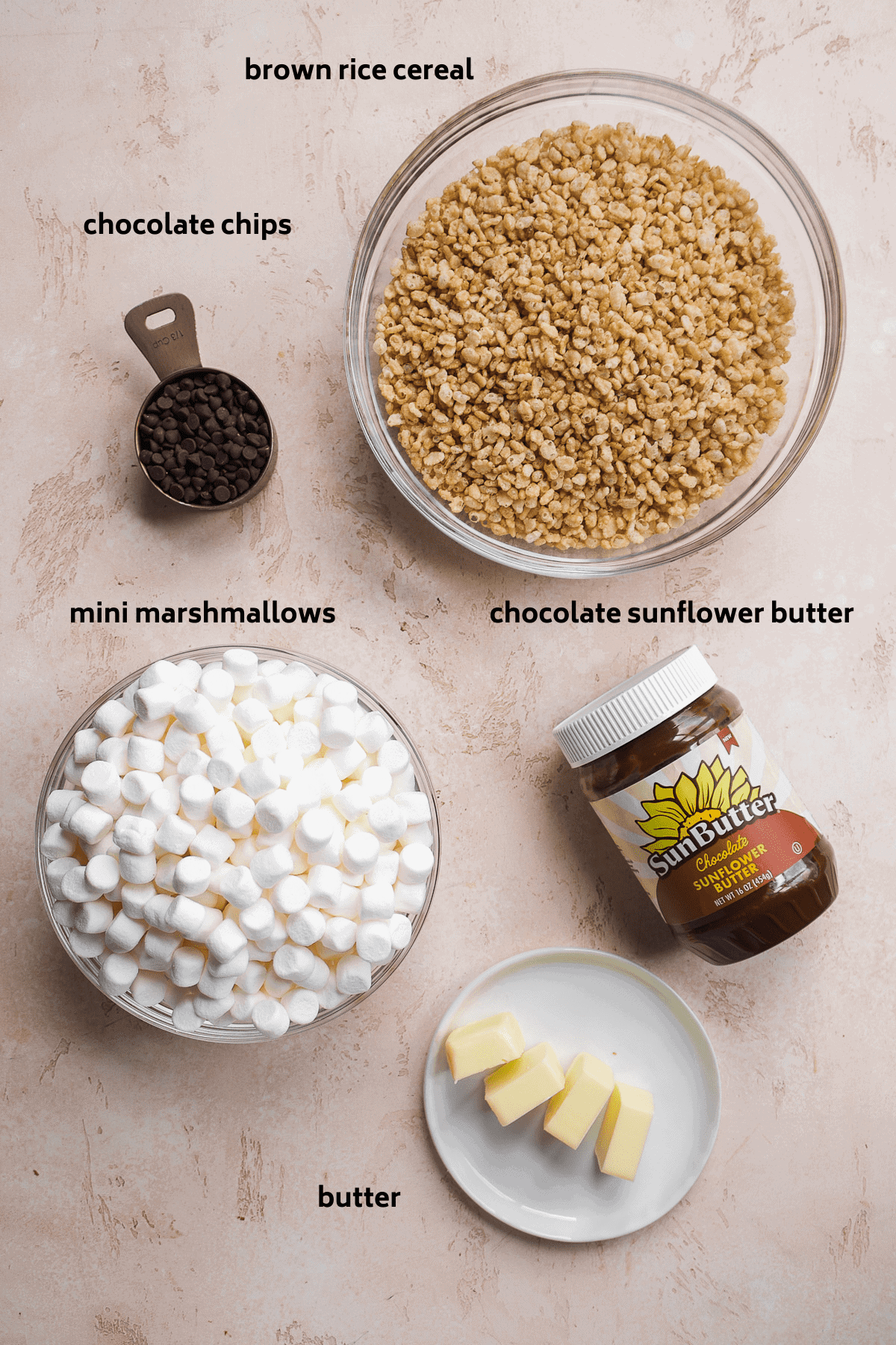 Rice krispie ingredients in bowls on a pink surface with text in black.