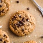 Peanut butter cookies with chocolate chips on top on parchment paper.