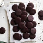 Vegan thin mints on a cooling rack with parchment paper.
