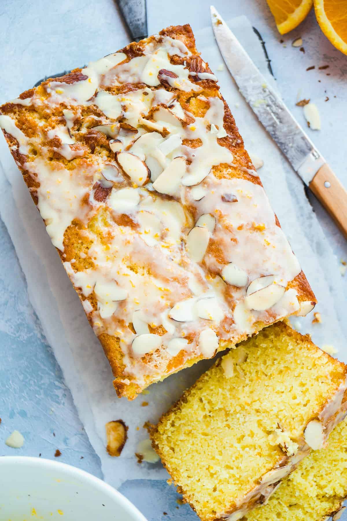 Overhead view of an orange pound cake loaf with almonds on top.