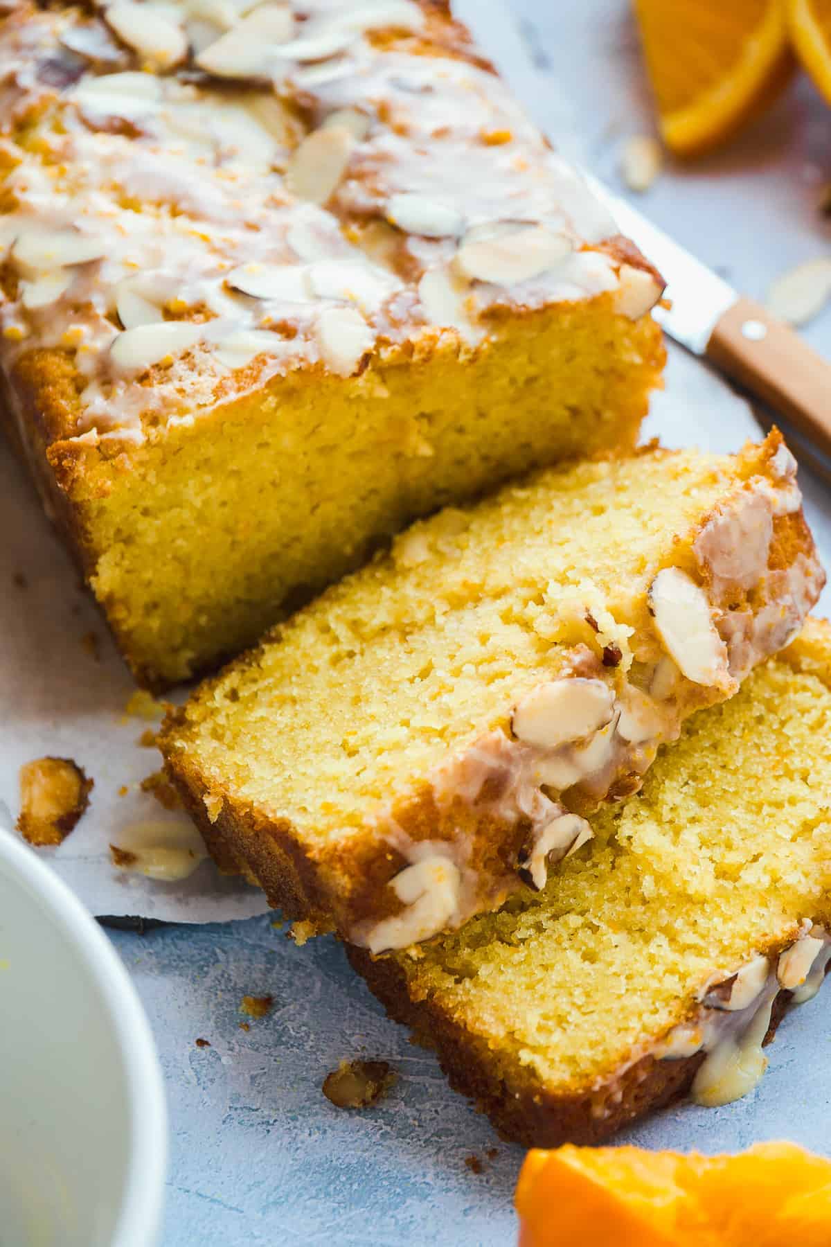 Orange pound cake with slices falling in front.