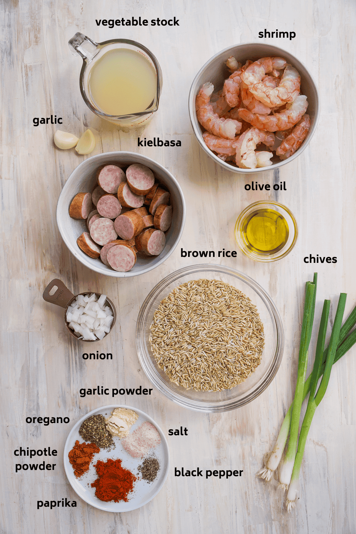 Cajun shrimp skillet ingredients on a brown surface with black labels.