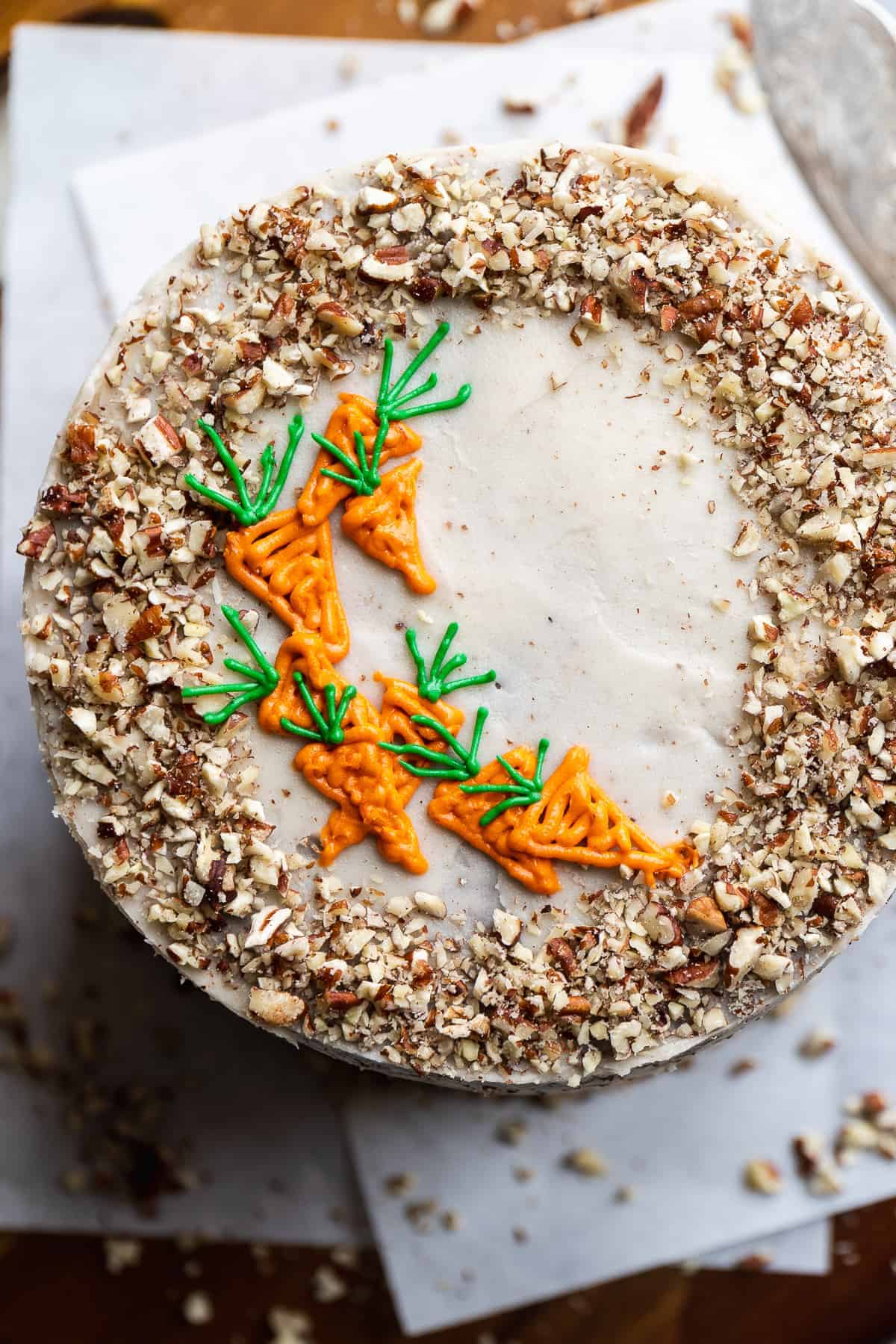 Overhead view of a chocolate carrot cake with carrots piped on top.