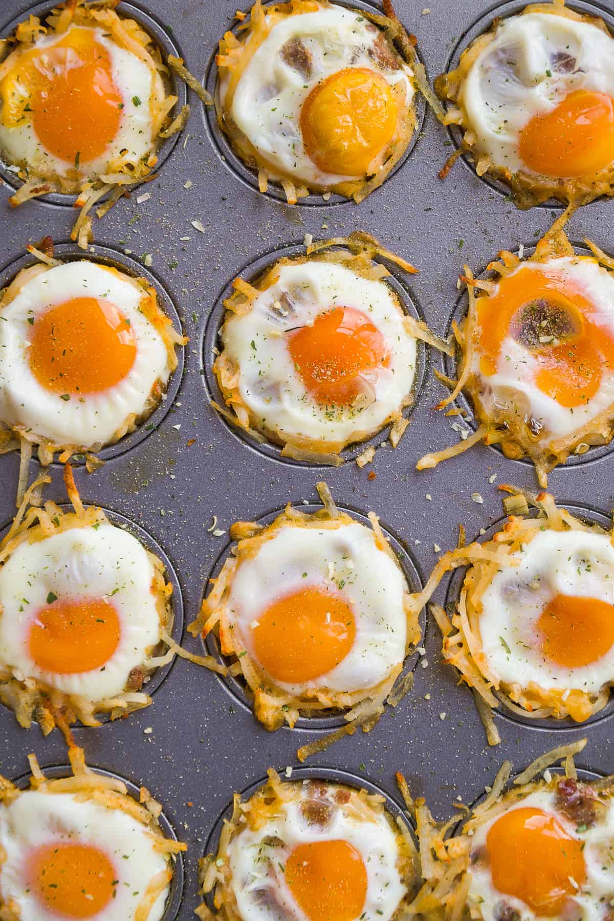 Overhead view of hash brown egg cups baked in a muffin tin.