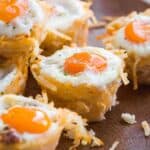 Hash brown egg cups on a wooden platter.