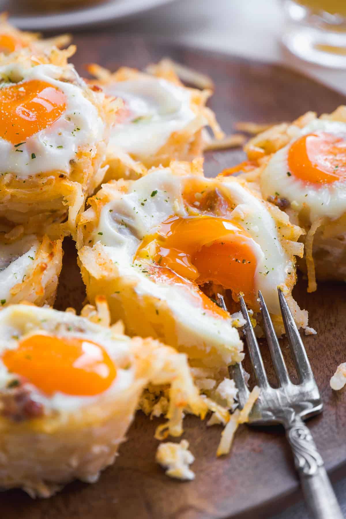 Hash brown egg cups with a fork taking a bite out of one.