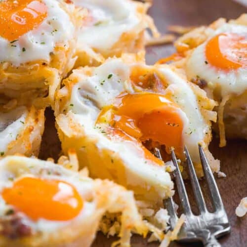Hash brown egg cup with a fork taking a bite of one.
