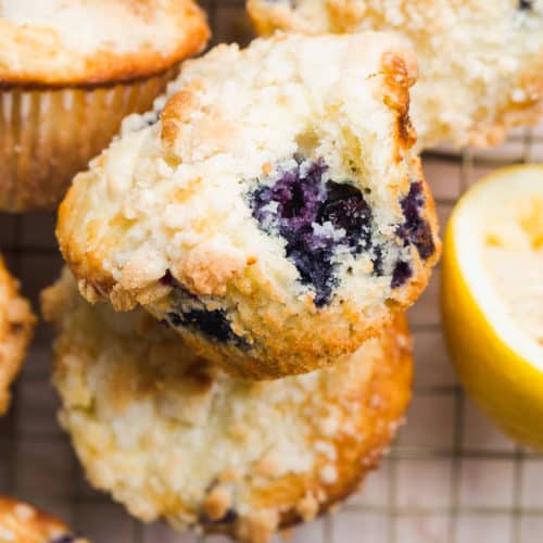 Lemon blueberry muffins scattered on a wire rack.
