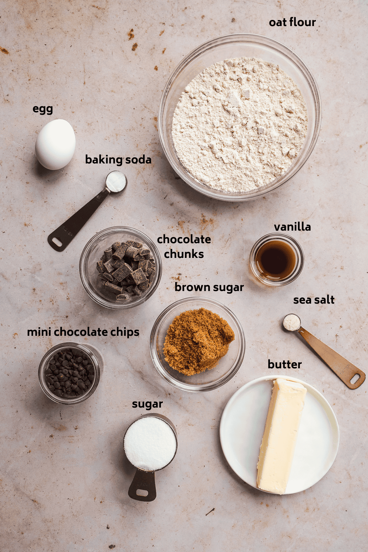 Oat flour cookie ingredients on a tan surface with labels in black.