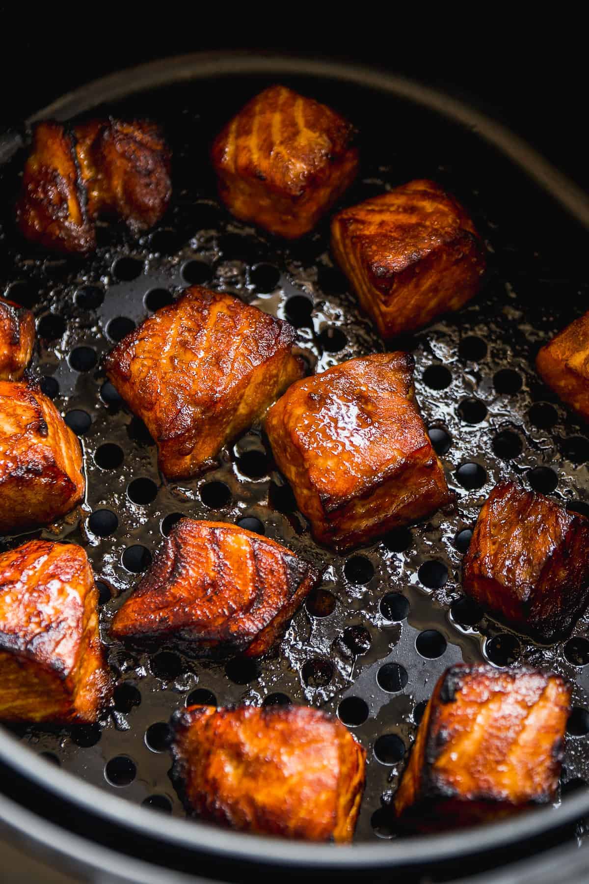 Cooked salmon chunks in an air fryer.