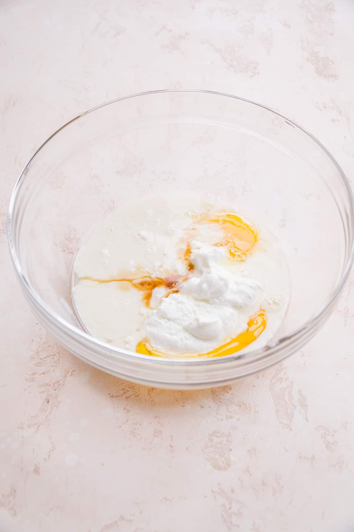 Clear bowl with greek yogurt and lemon about to be mixed.