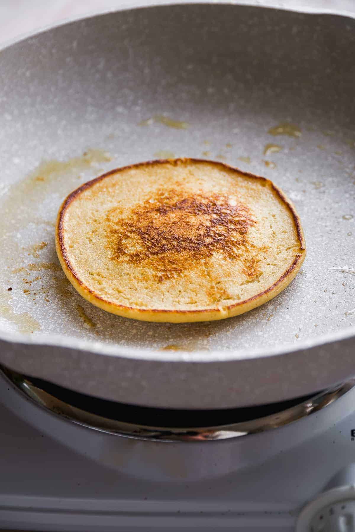 Pancake cooking in a gray skillet.