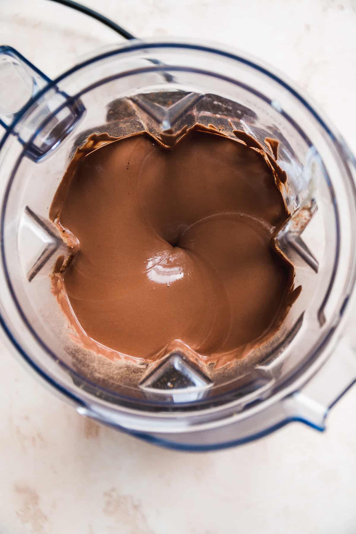 Overhead view of a blender with chocolate yogurt mixture.