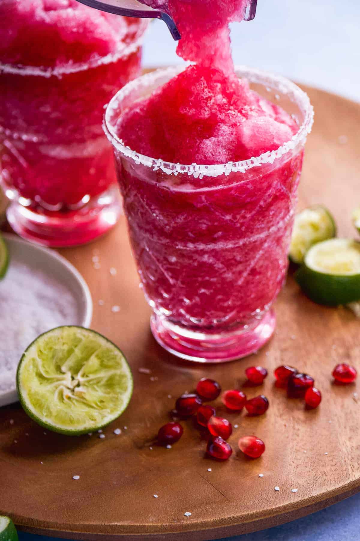 Frozen pomegranate margarita being poured into a glass.