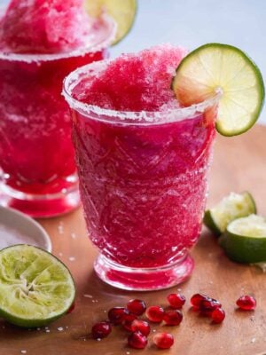 Glass with a frozen pink margarita mocktail.