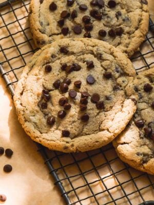 Oat flour chocolate chip cookies scattered on a wire rack.