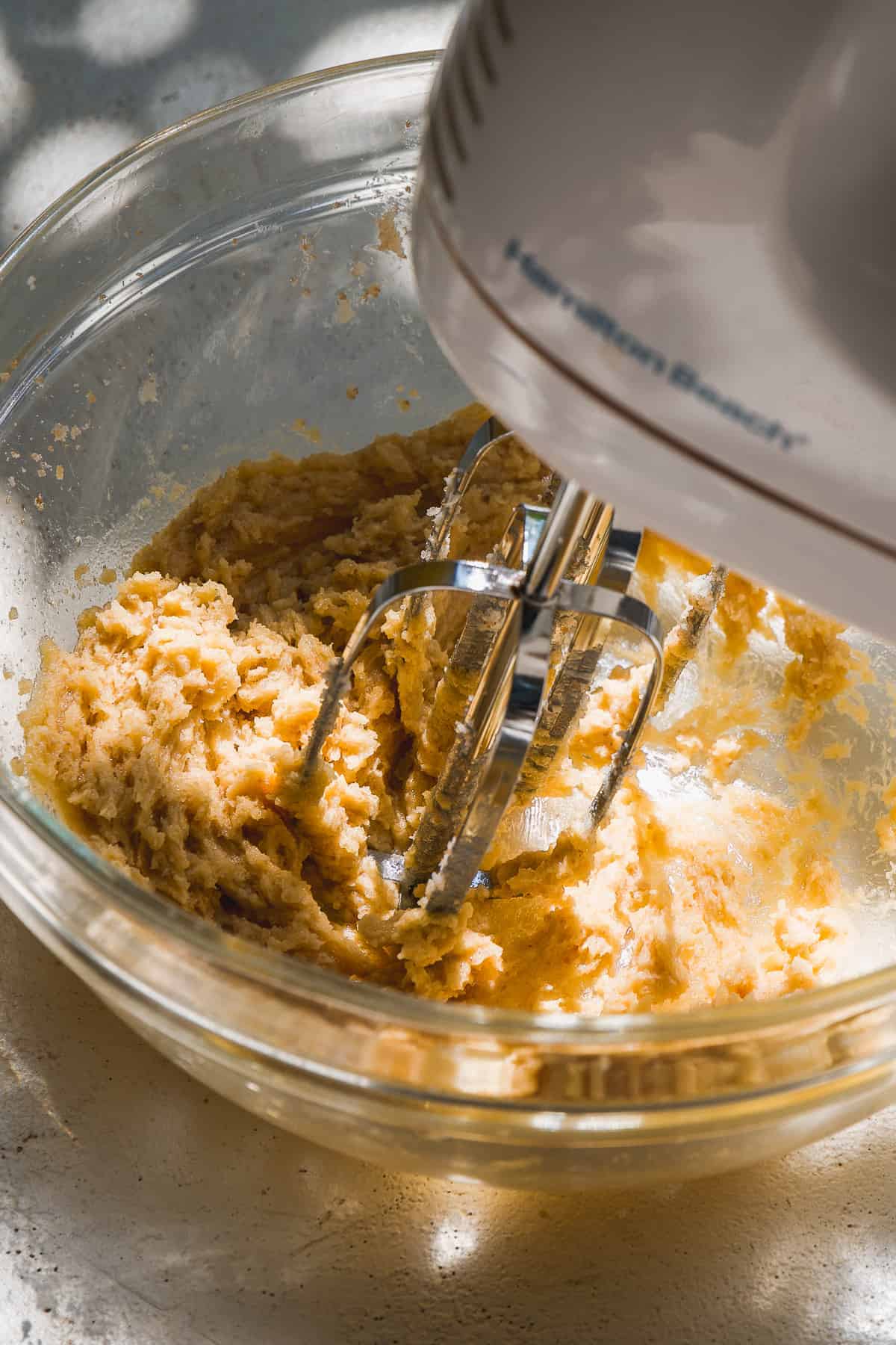 Bowl with a mixer mixing cookie dough.