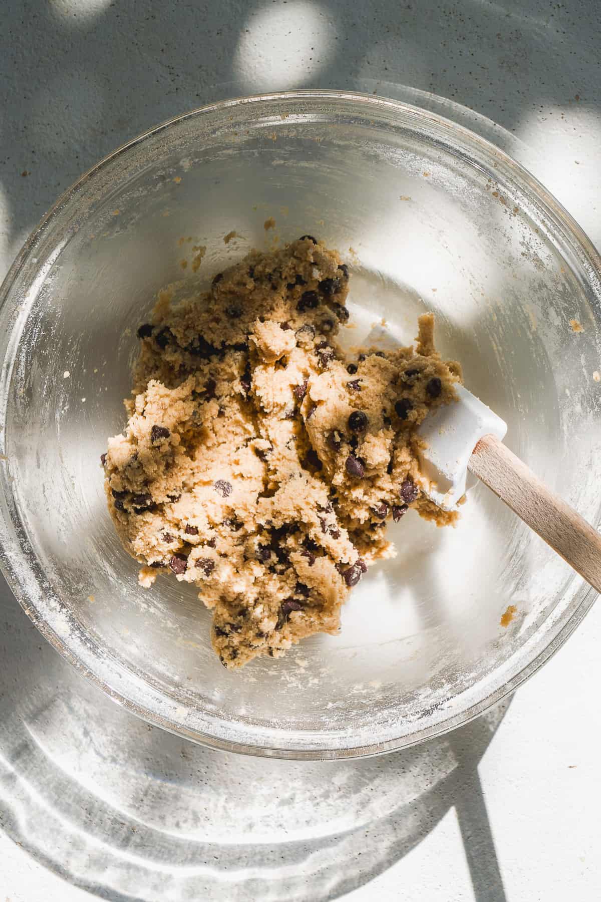 Oatmeal chocolate chip cookie dough in a clear bowl.