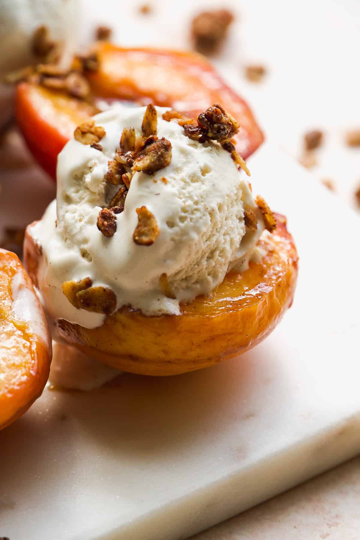 Roasted peach with ice cream on top and oat crumbles.