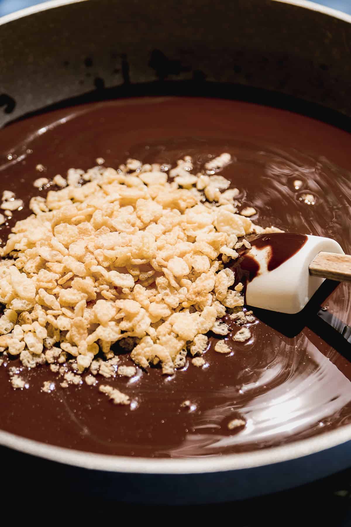 Dark chocolate melted in a skillet with brown rice  crisps about to be mixed in.