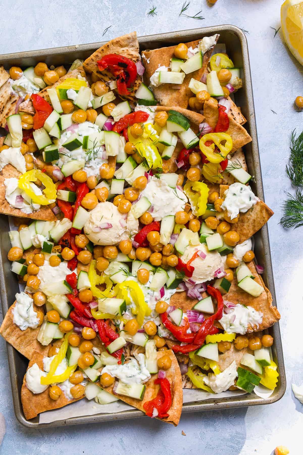 Overhead view of greek nachos in a baking pan.