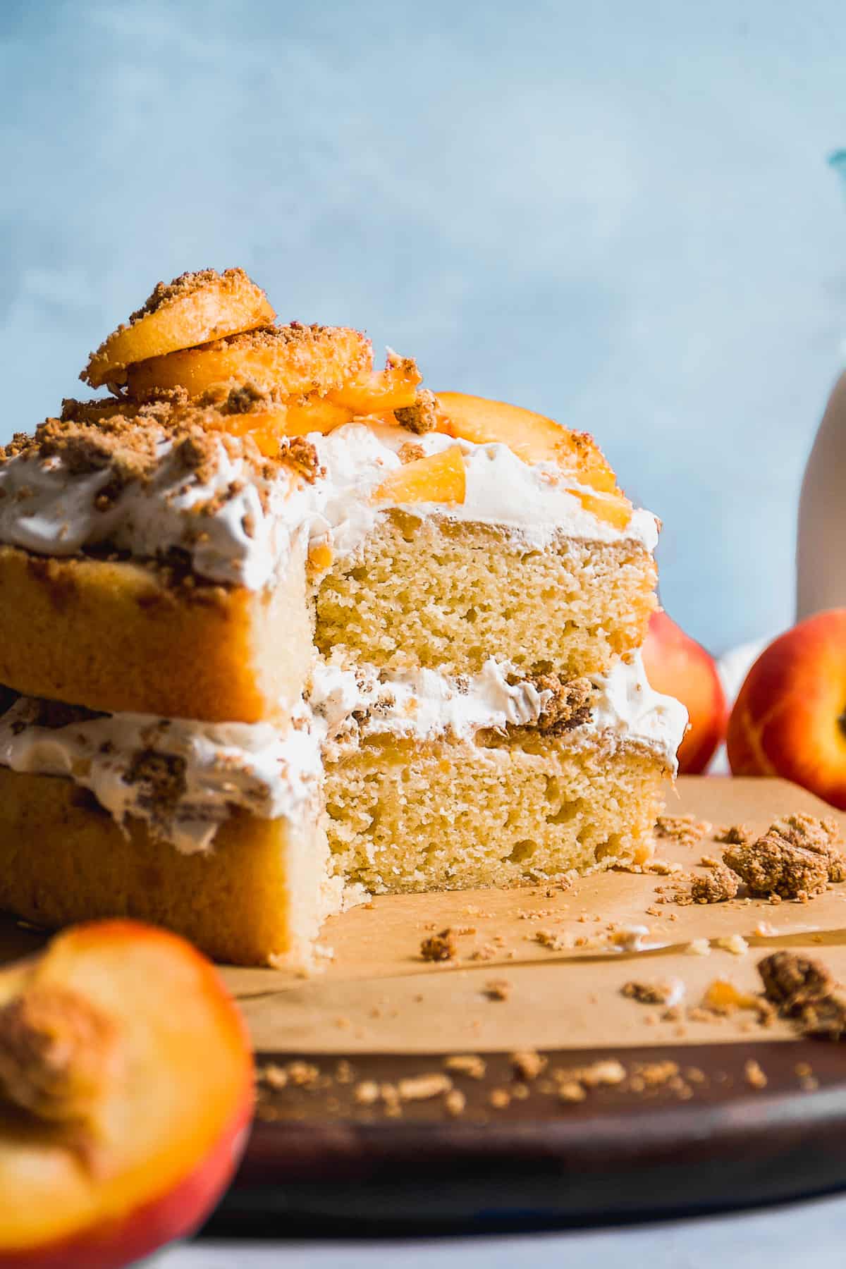 Peach cobbler layer cake with a pile of cool whip and peach slices on top.