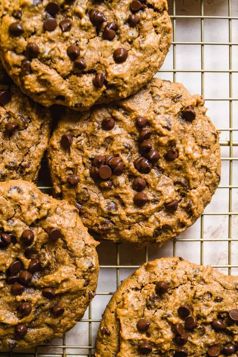 Peanut butter chocolate chip cookies scattered on a wire rack.