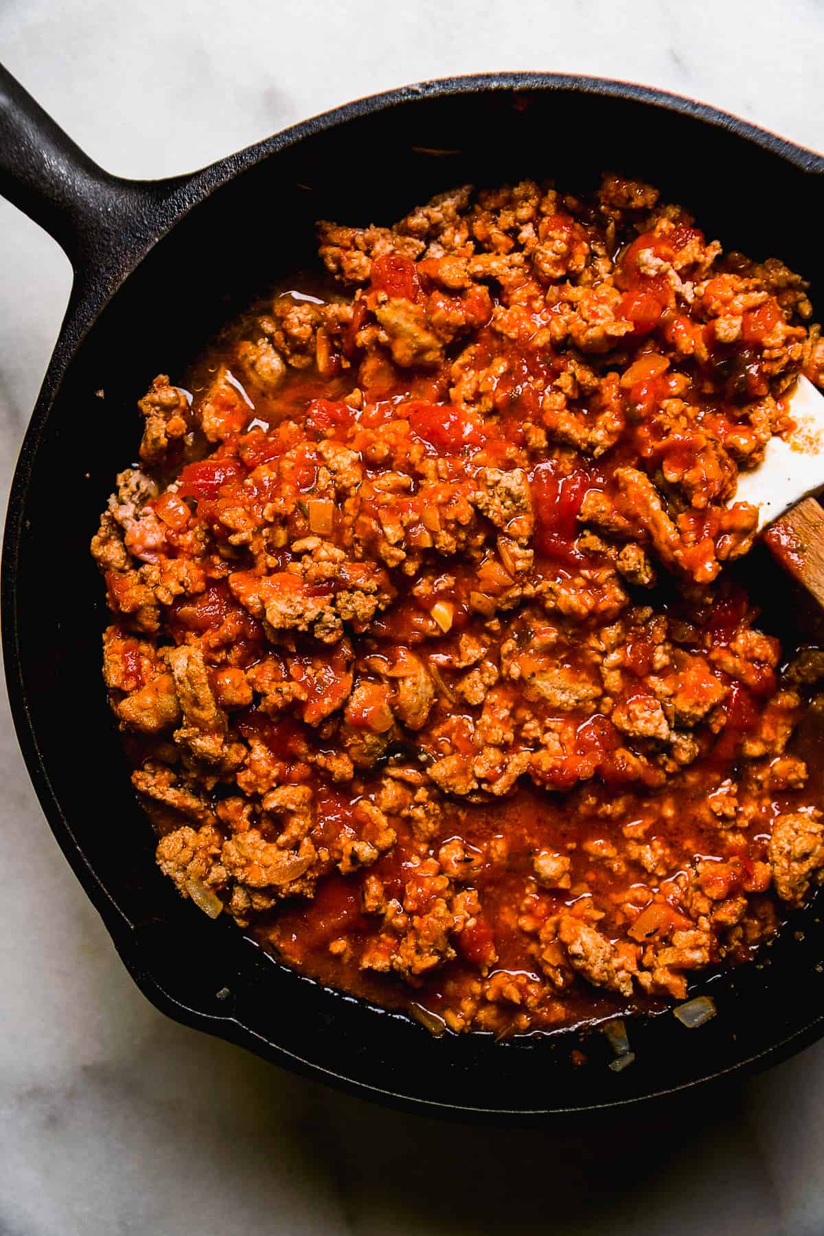 Tomato sauce in a black cast iron pan.