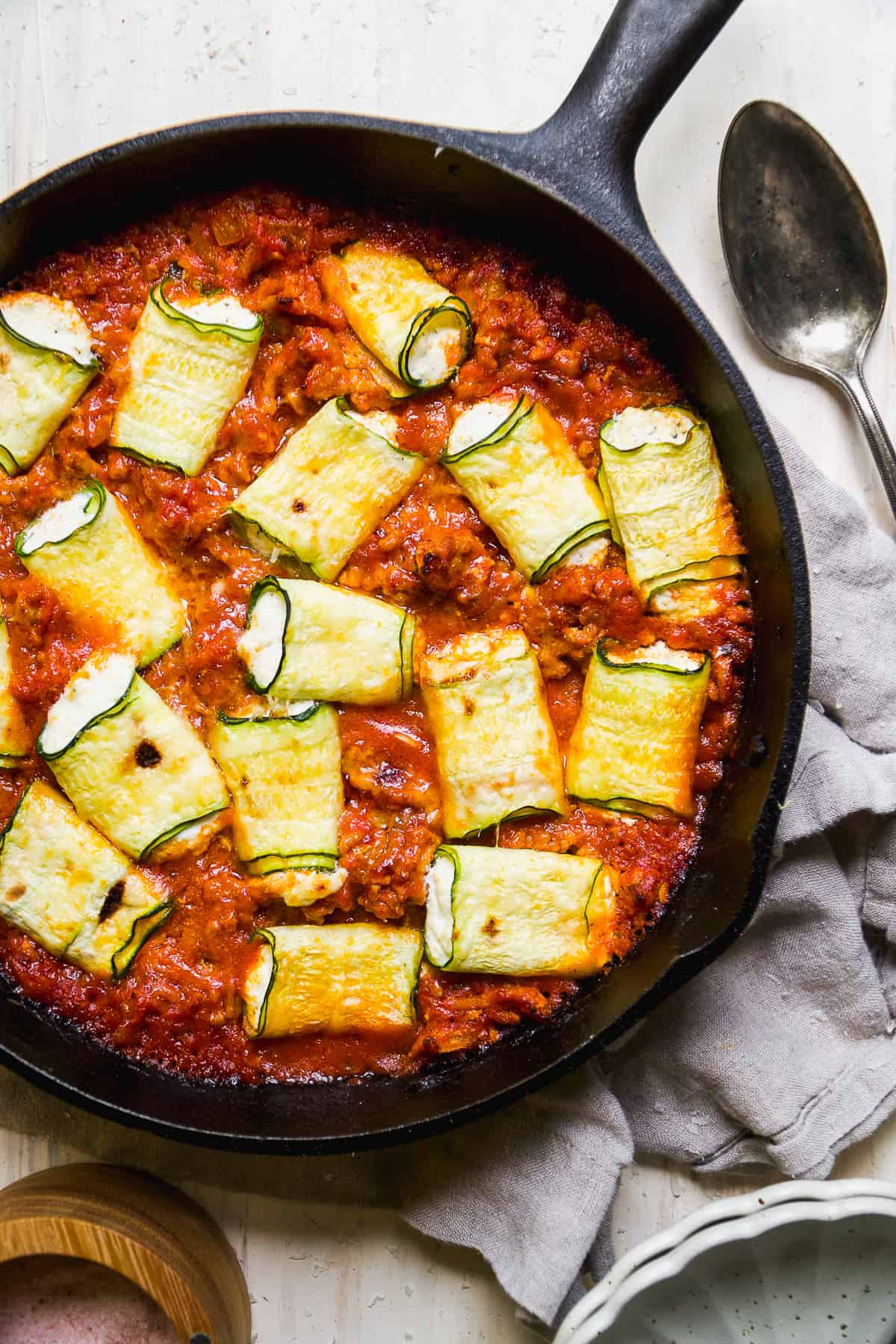 Overhead view of zucchini involtini in a black pan.