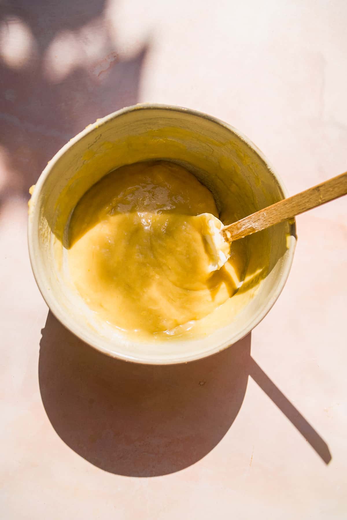 Lemon cake batter in a bowl with a rubber spatula.