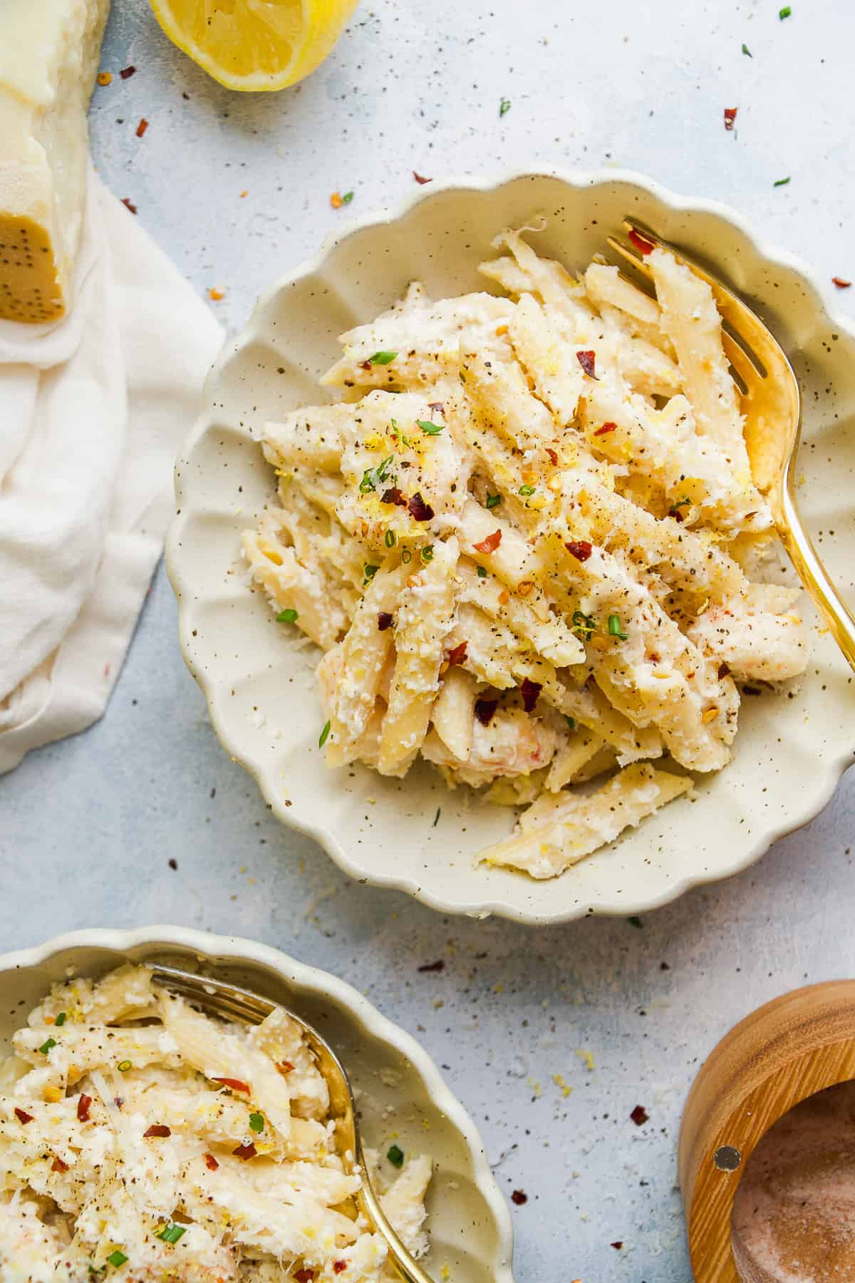 Overhead view of lemon pasta with ricotta and spices in a bowl.