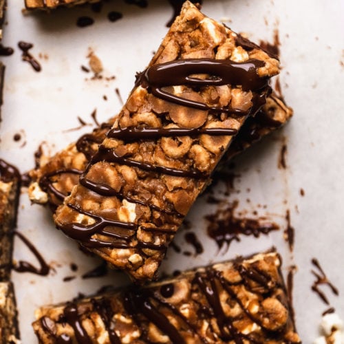 Peanut butter cheerio bars with chocolate on a white surface.