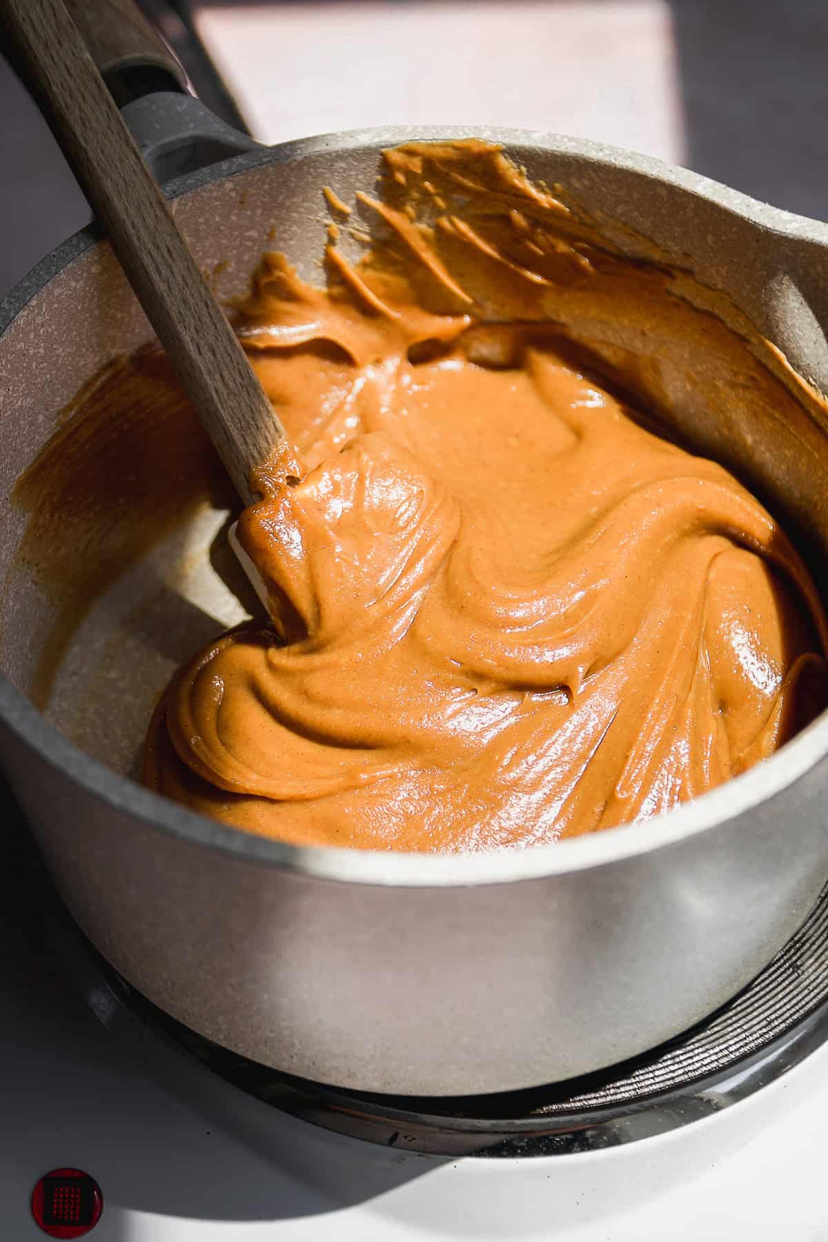 A gray pot with melted peanut butter inside.