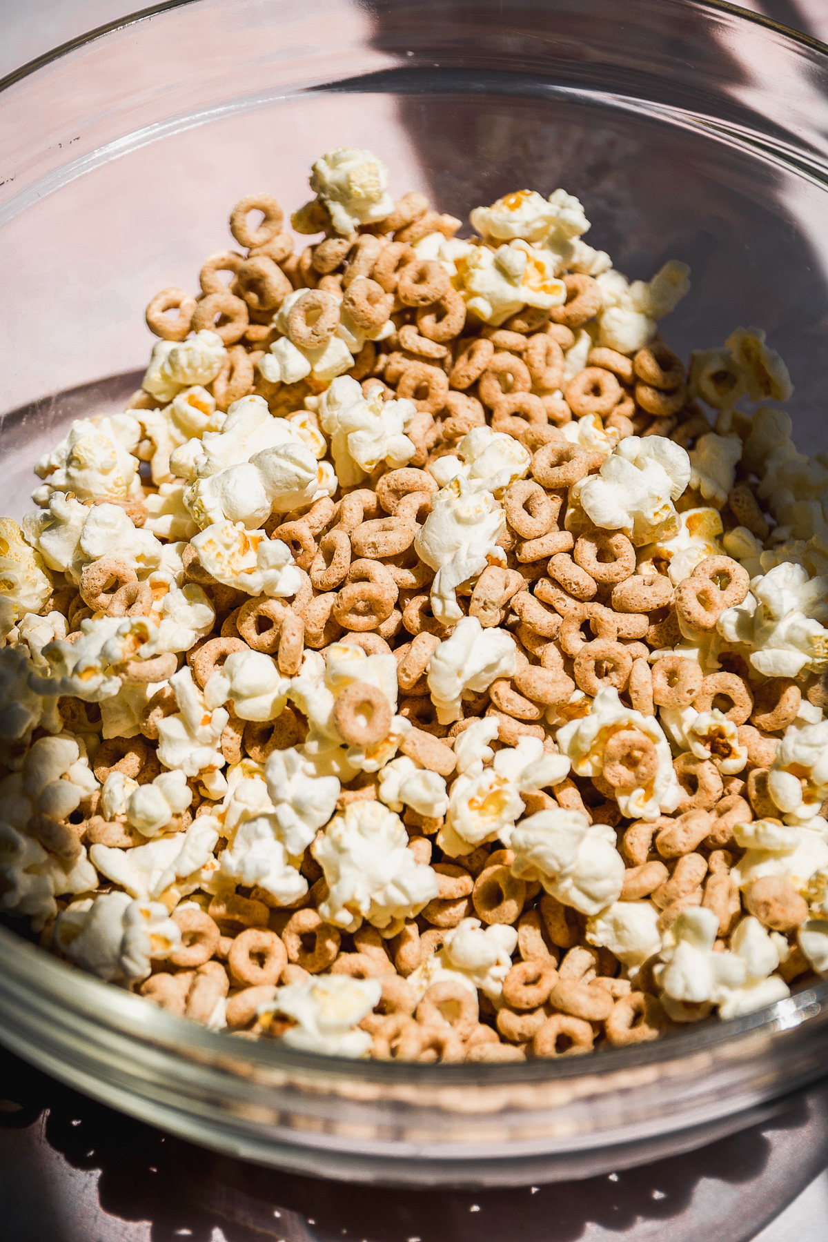 Large glass bowl with cheerios and popcorn.