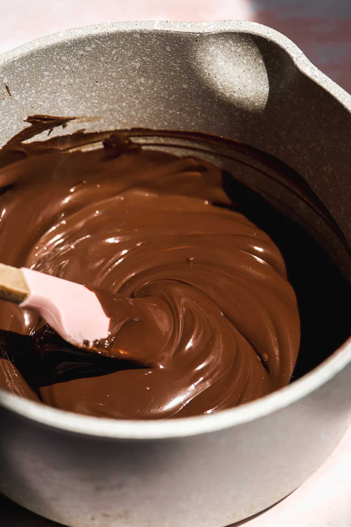 Chocolate melted in a gray pot.