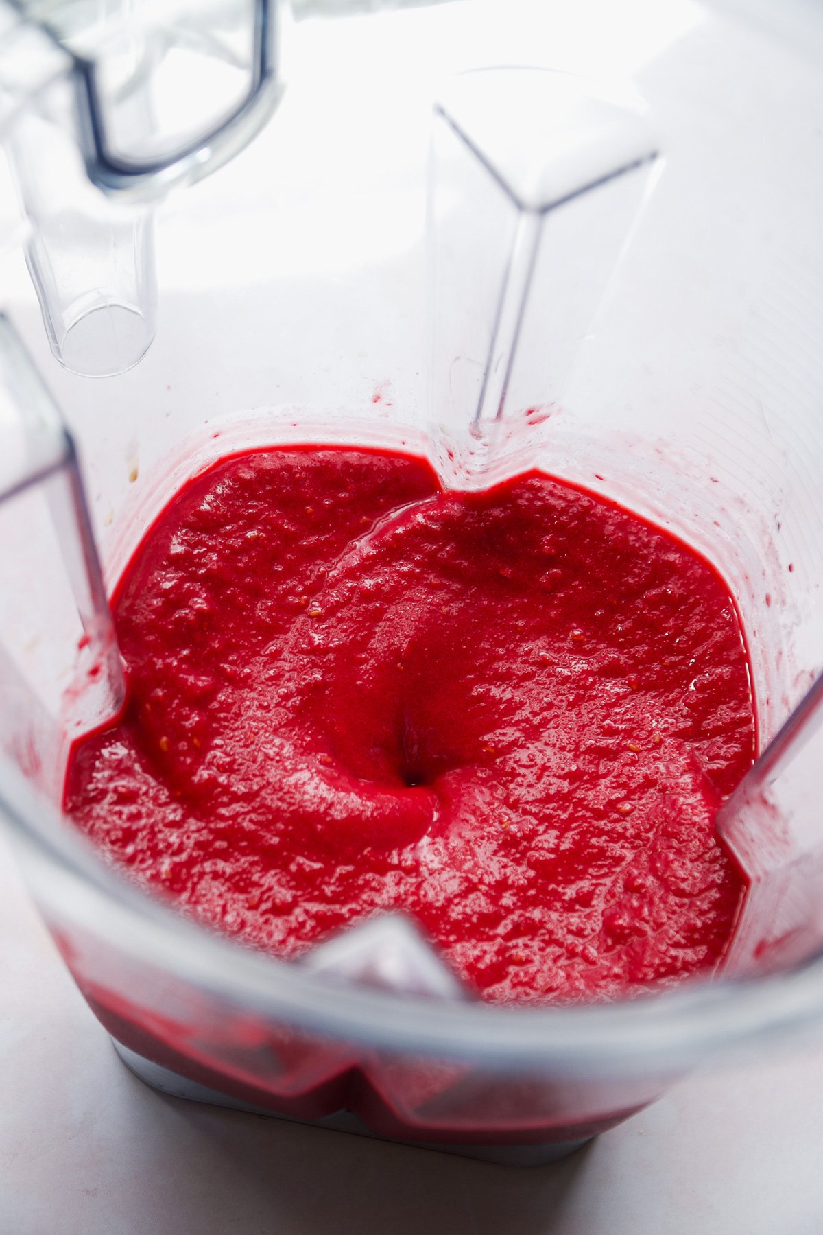 Raspberry sherbet blended up in a blender.