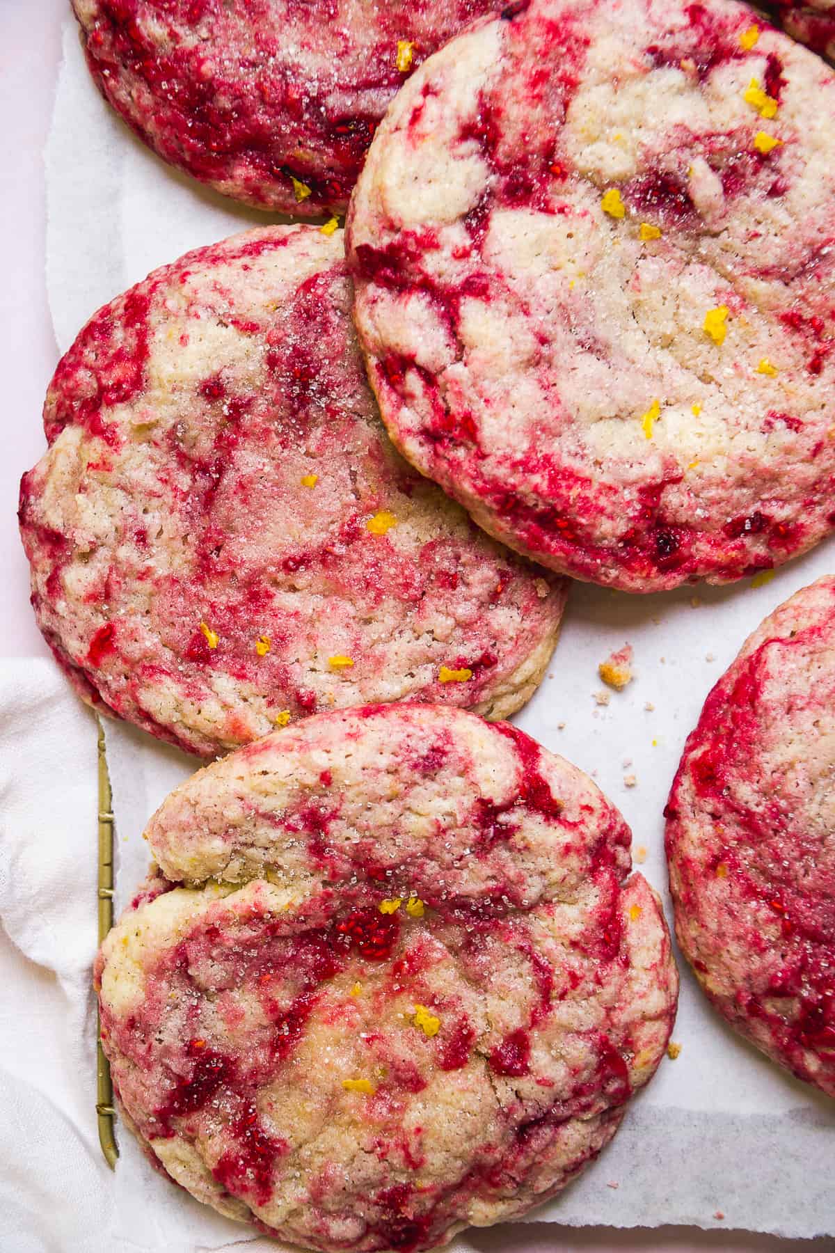 Raspberry lemonade cookies scattered on parchment paper.