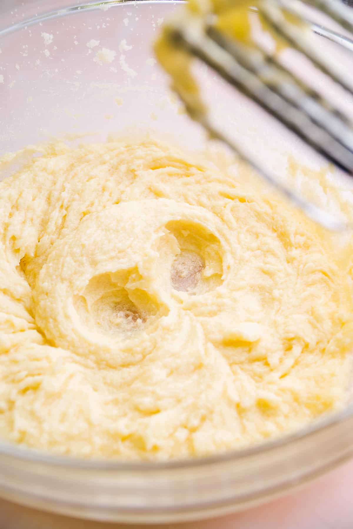 Butter and sugar mixed together in a glass bowl.