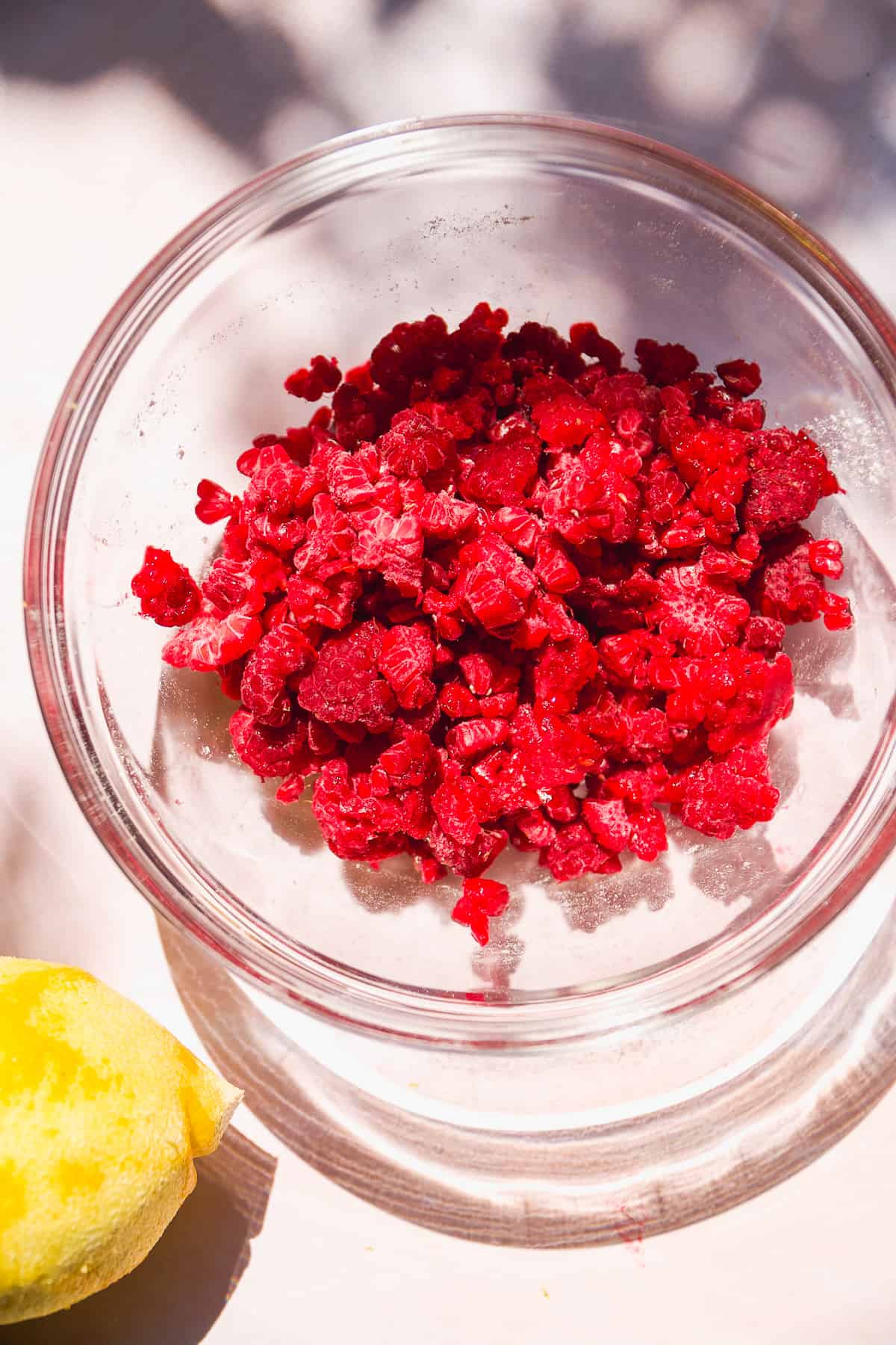Frozen raspberries in a glass bowl.