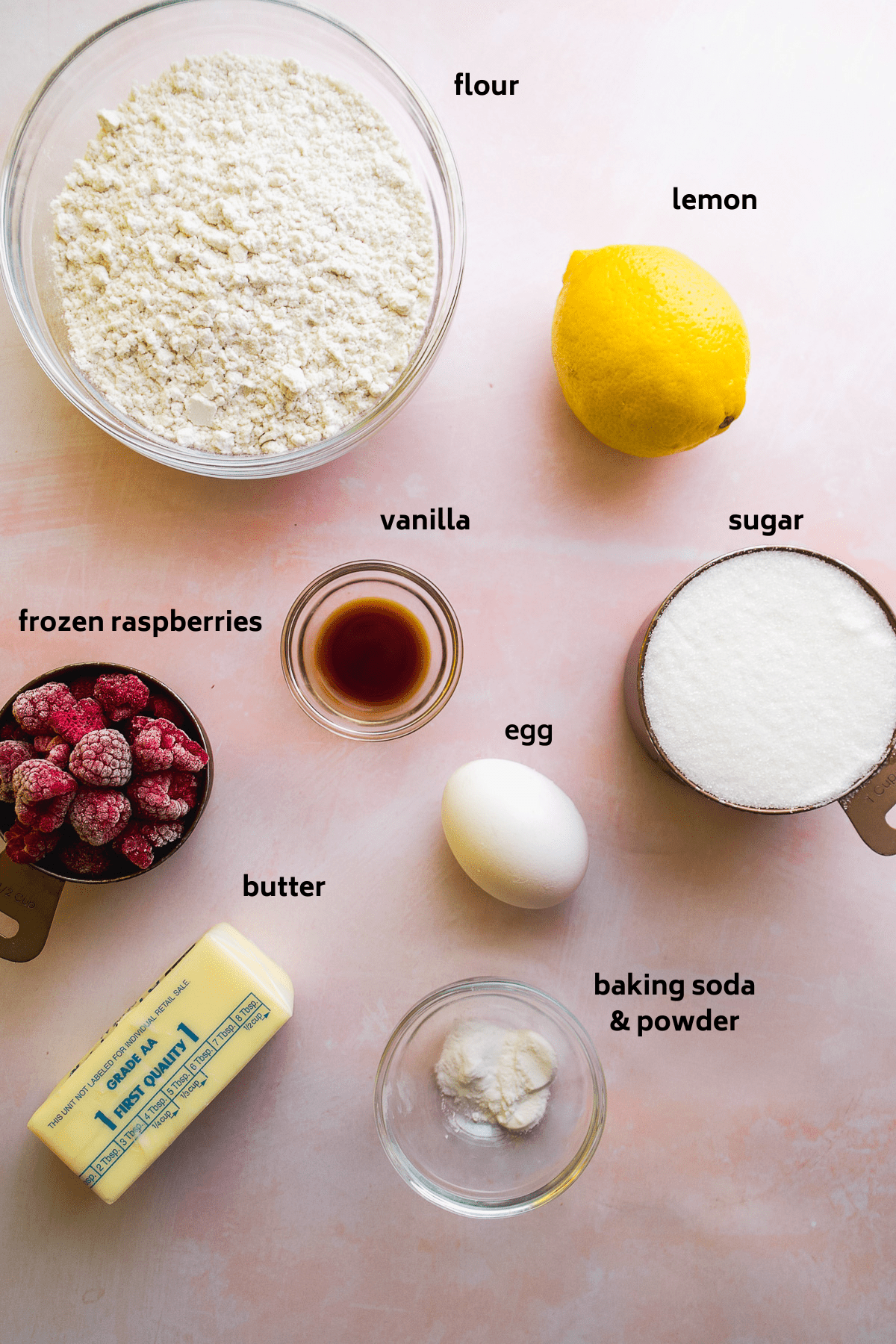 Raspberry lemonade cookie ingredients on a pink surface with labels in black.