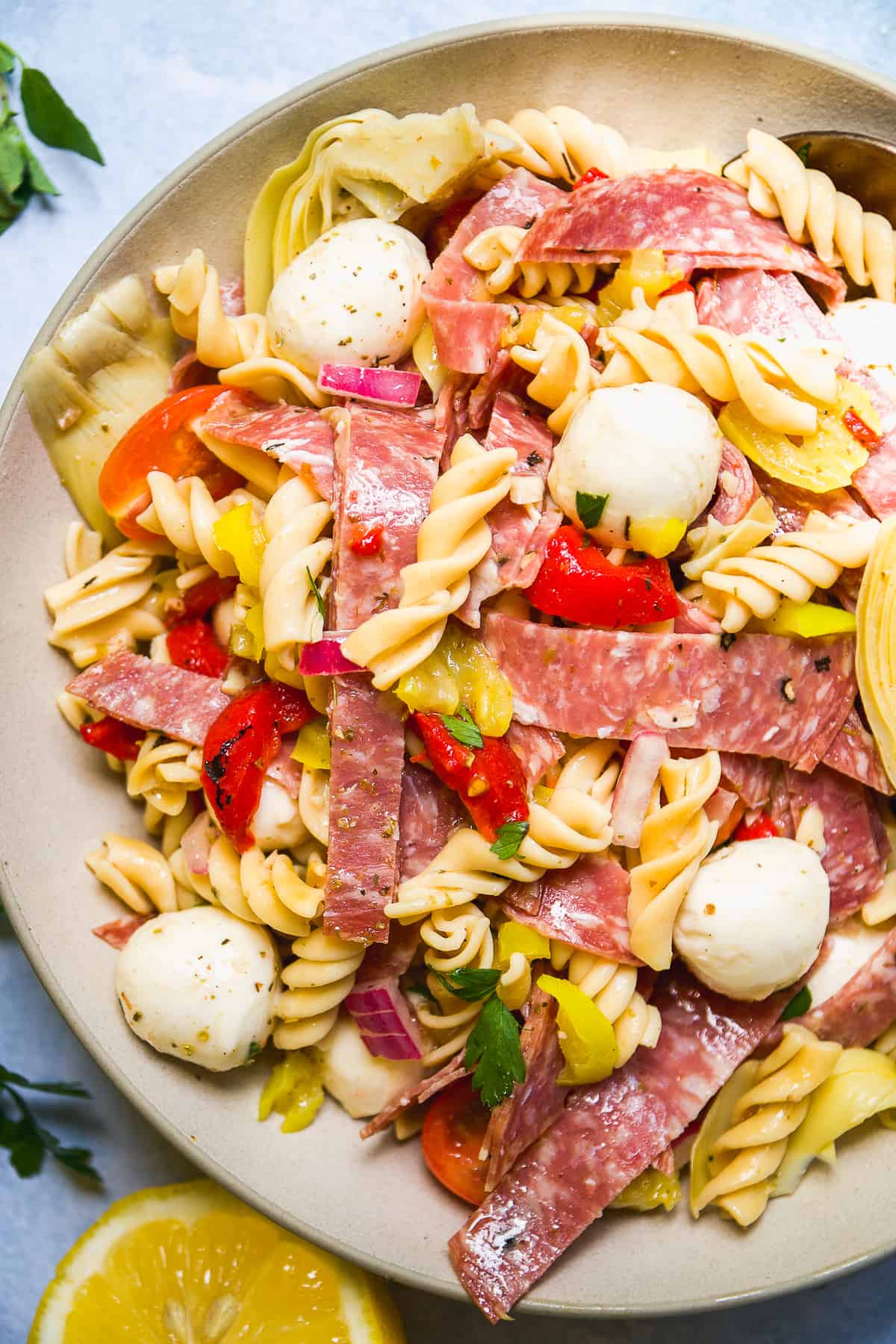 Plate of Italian pasta salad with mozzarella and salami.