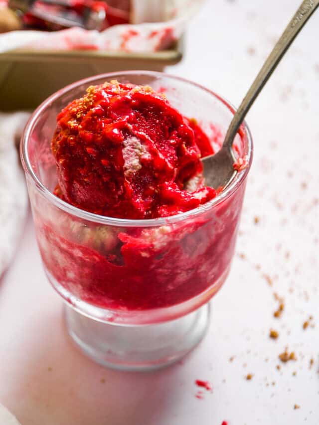 Raspberry cheesecake sherbet in a glass dish with a spoon
