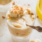 Small glass of dairy free banana pudding with a spoon resting inside.