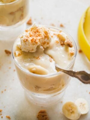 Small glass of dairy free banana pudding with a spoon resting inside.